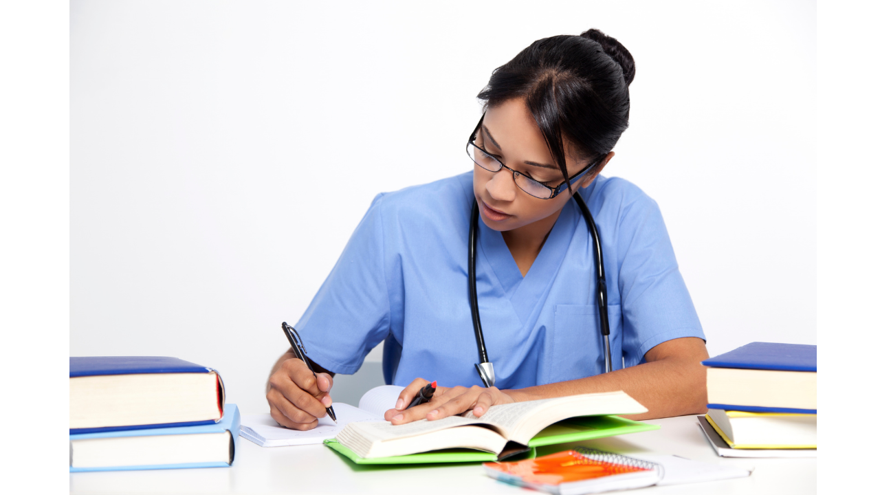 Nursing student studying with textbooks and notes